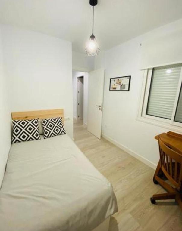 a bedroom with a bed and a desk and a window at San Sebastián in Pasajes Ancho