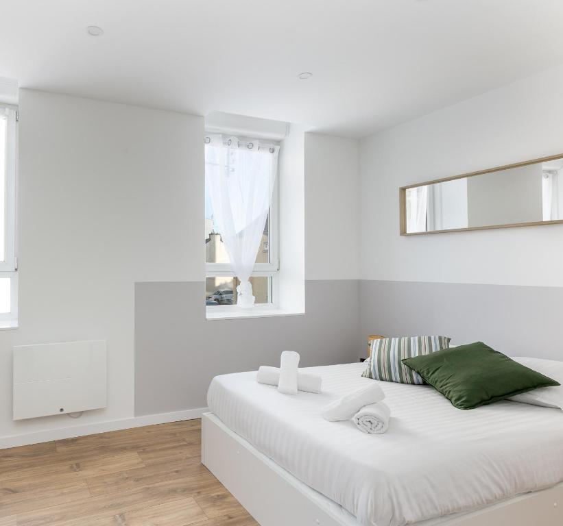une chambre blanche avec un lit blanc et une fenêtre dans l'établissement Fée Viviane, à Brest