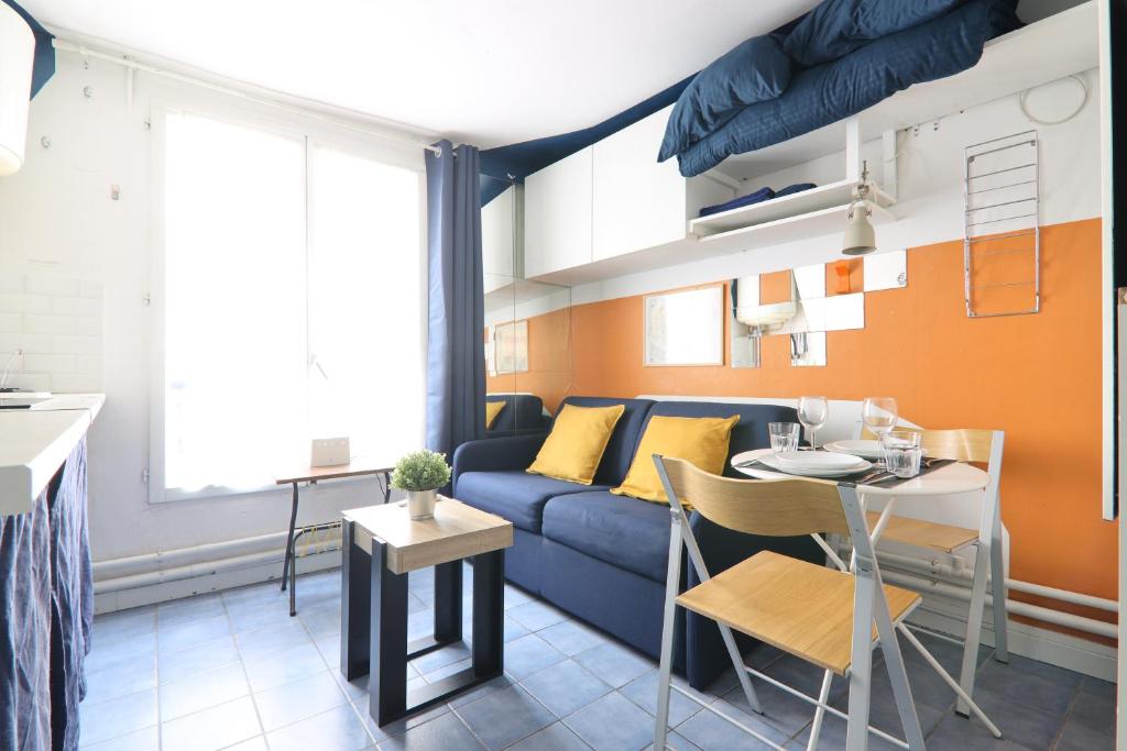 un salon avec un canapé bleu et une table dans l'établissement Studio Appartement Quartier Republique Free Netflix, à Paris