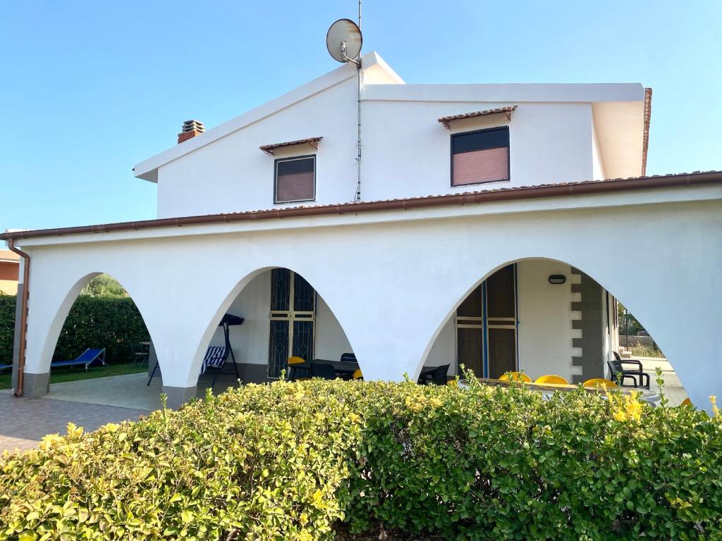 a white house with arches and a hedge at Pearl of the sea in Arenella