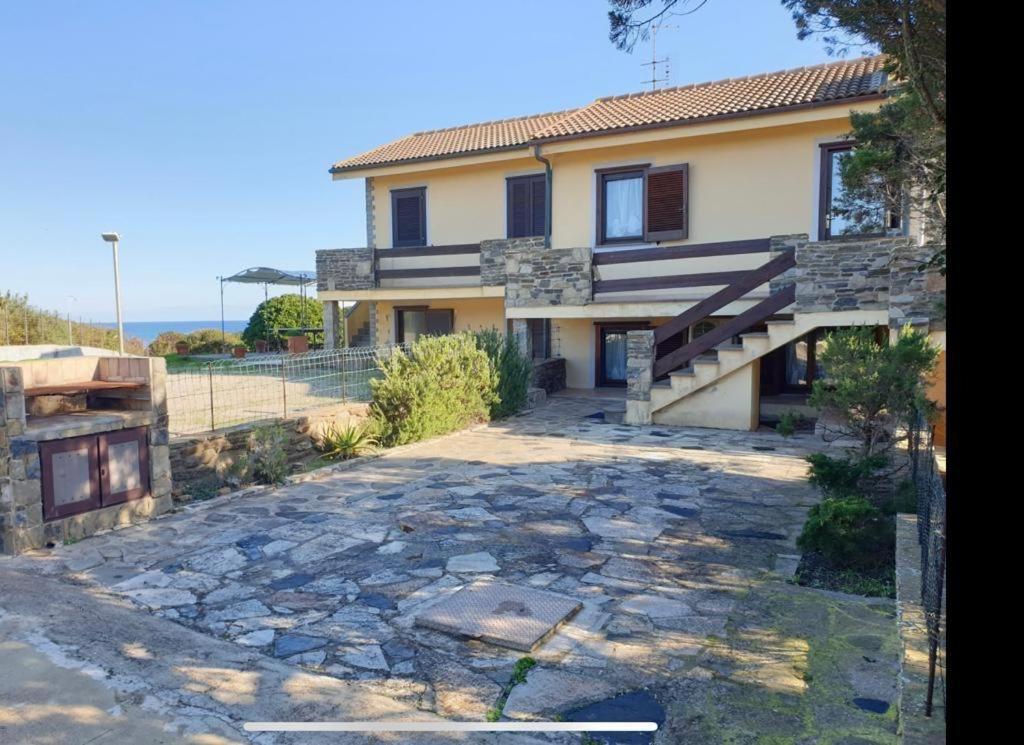 a house with a stone driveway in front of it at La Pelosa House 2 in Stintino