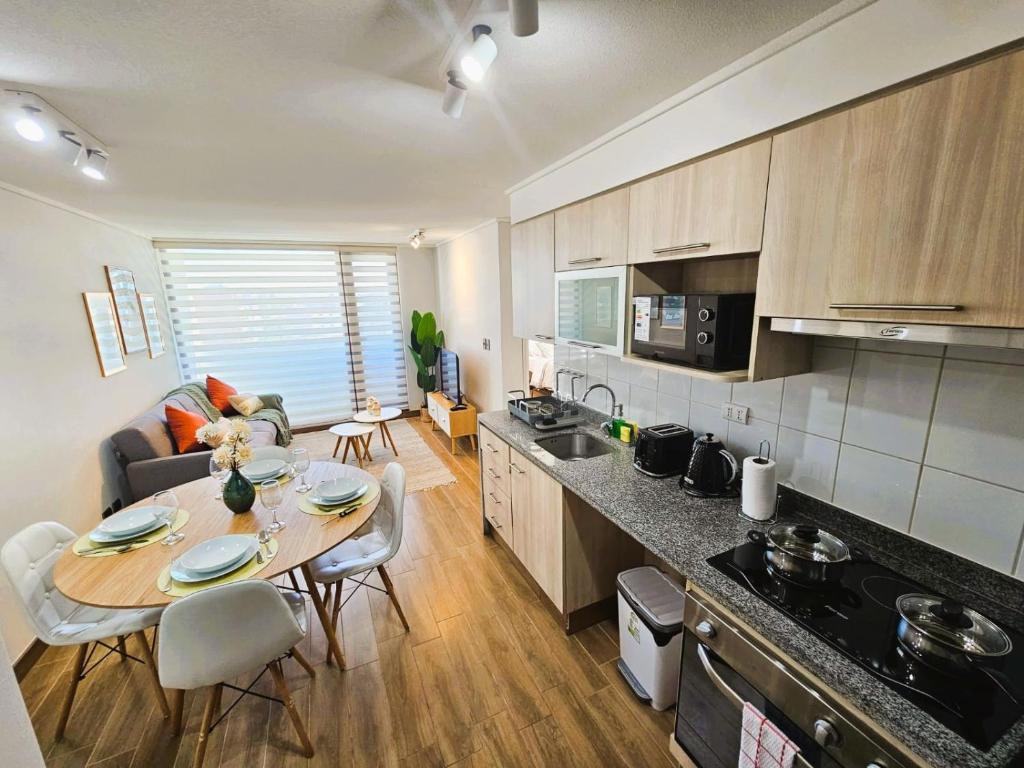 a kitchen and living room with a table and chairs at 2D con estacionamiento Fantastico Depto - D'Home in Concepción