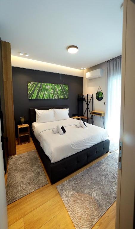 a bedroom with a large white bed with a large window at Lago Suite in Kastoria
