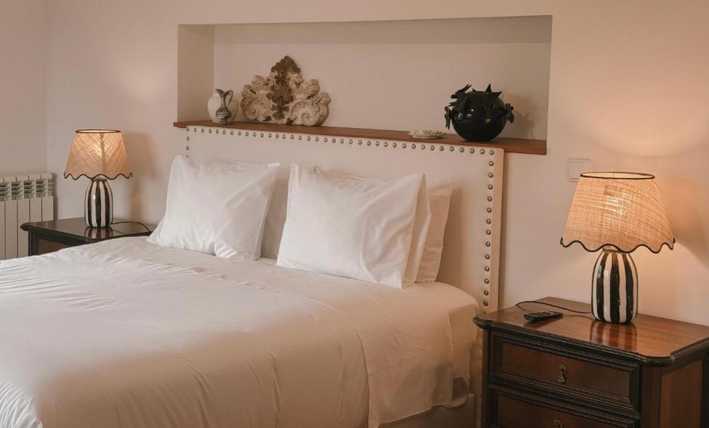 a bedroom with a white bed with two lamps at Quinta Amarela - B&B in Nazaré