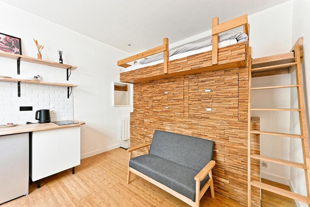 une chaise dans une pièce avec un mur en briques dans l'établissement Studio avec Mezzanine Boulevard Voltaire-V, à Paris