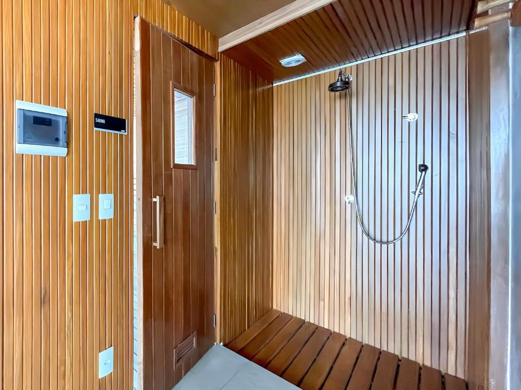 Nine: Conforto e Sofisticação no Jardim Paulista في ساو باولو: ساونا مع دش وتلفزيون على الحائط