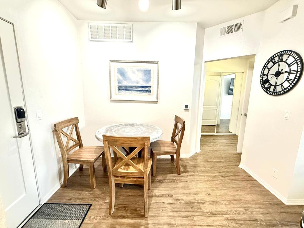 a dining room with a table and chairs and a clock at Spacious and Central with a Pool View in Los Angeles