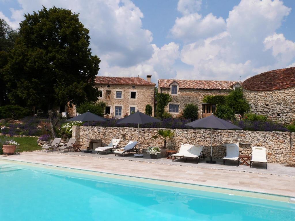 un complexe avec une piscine et un bâtiment dans l'établissement Manoir Beauregard Dordogne, à Clermont-de-Beauregard