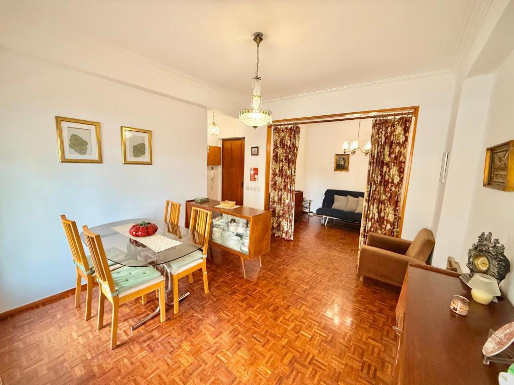 a dining room and living room with a table and chairs at Casa da Mariazinha in Costa da Caparica