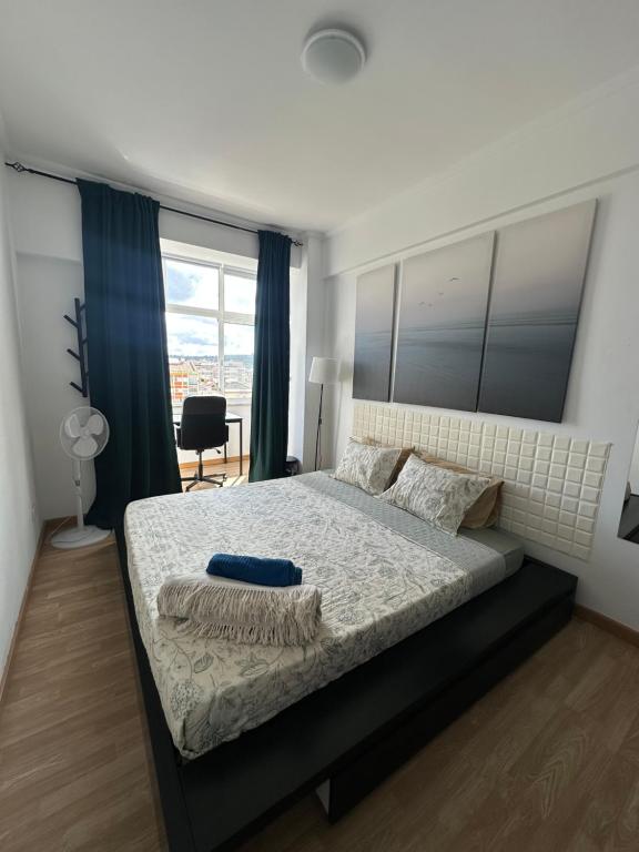a bedroom with a large bed and a window at Hostel Nosso Lar in Odivelas