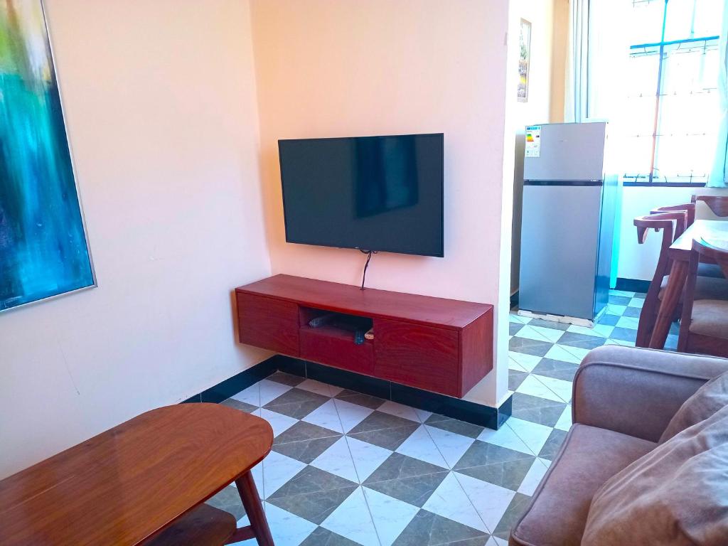 a living room with a flat screen tv on a wall at Bleivory Homes2 in Dar es Salaam