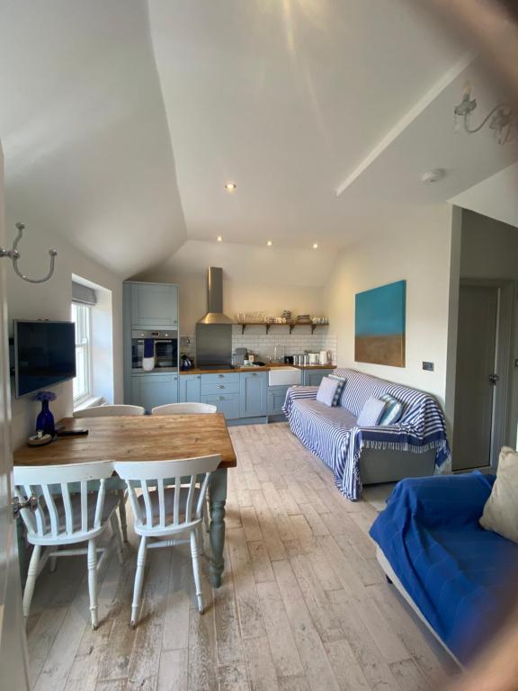 a kitchen and living room with a table and a couch at Little Dolly sea view 2 bedroom apartment, St Ives town, dog friendly in St Ives