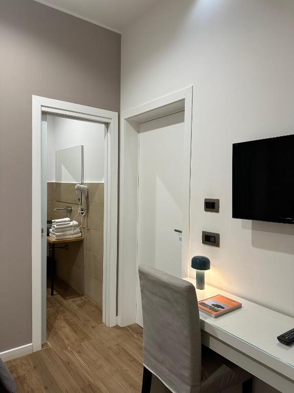 Pokój z biurkiem z krzesłem i telewizorem w obiekcie Olivia Rooms Eurialo w mieście Belvedere