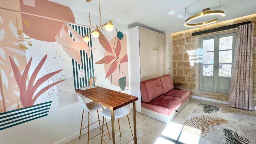 un salon avec une table et un canapé rouge dans l'établissement Noon by Home&Art, à Montpellier