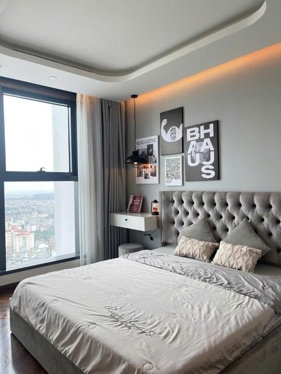 a bedroom with a large bed with a large window at LAD Homestay & Apartment Hải Phòng - Diamond Crown Lê Hồng Phong in Ðông Khê