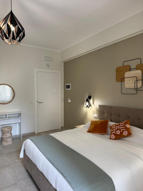a bedroom with a large white bed and a chandelier at Dimora dei Vespri 2 in Catania