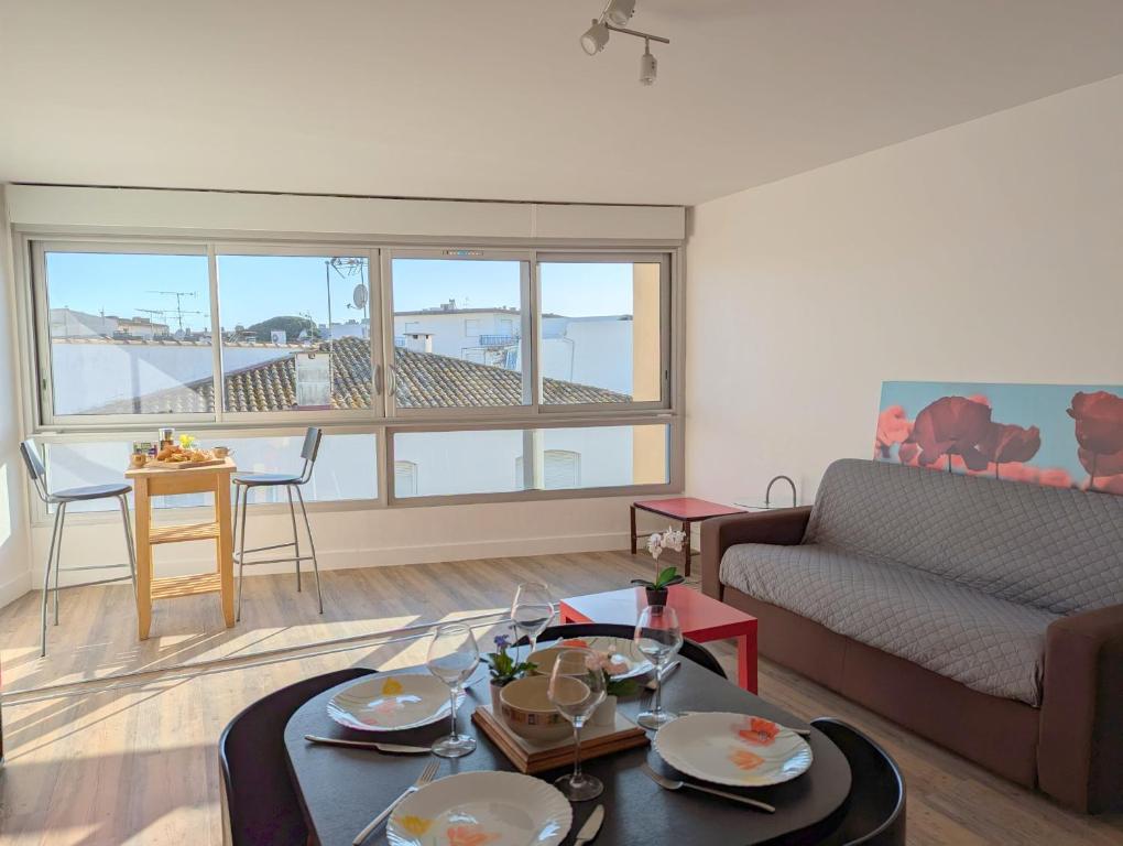 un salon avec un canapé et une table dans l'établissement Sol-y-Days Murènes, Grand studio confortable avec parking, proche du centre ville et de la plage, au Grau-du-Roi