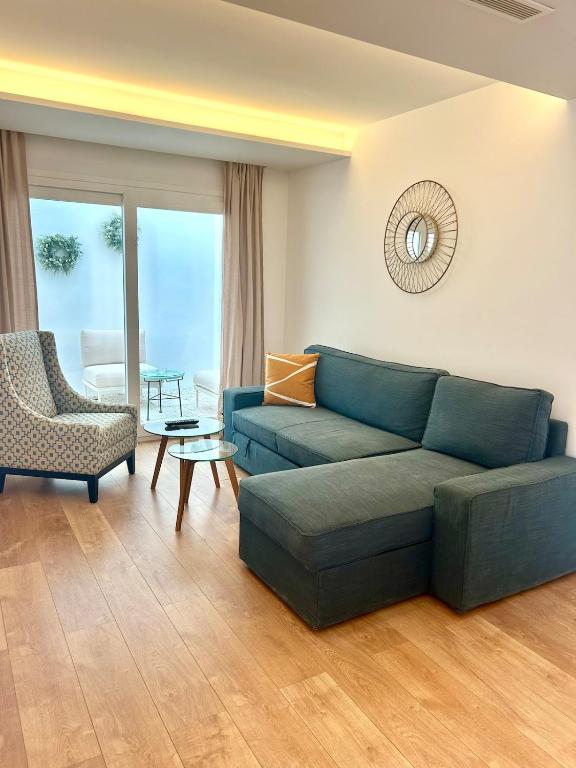 a living room with a blue couch and a chair at La casa de la Abuela in Marbella
