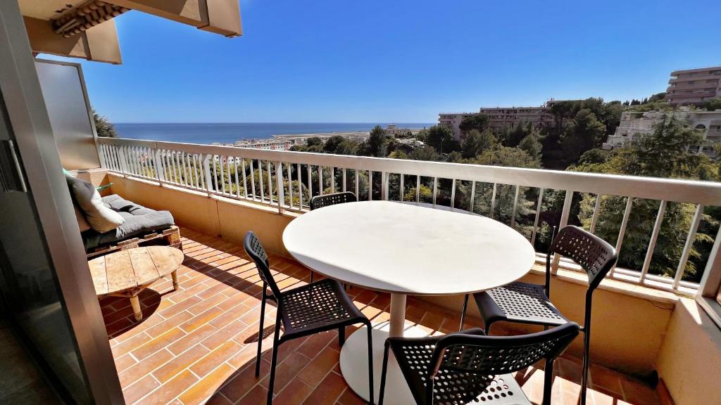 un balcon avec une table et des chaises et l'océan dans l'établissement Vista Mare, à Nice