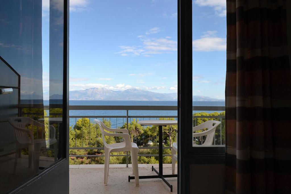 - un balcon avec deux chaises et une table avec vue dans l'établissement Hotel Miramare, à Xylokastro