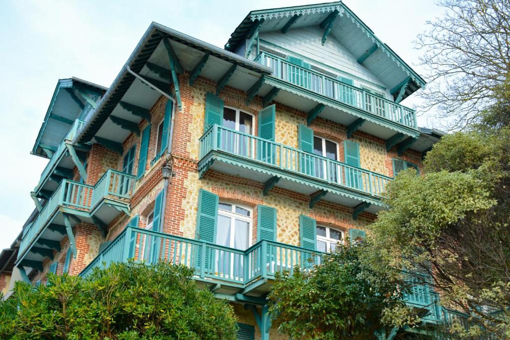 un immeuble d'appartements avec des balcons sur le côté dans l'établissement Villa d'exception vue sur mer, 9 chambres, à Trouville-sur-Mer