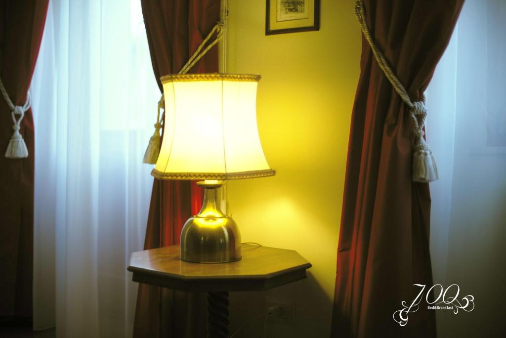 lampa siedząca na stole obok okna w obiekcie Luxury B&B '700 w mieście Ascoli Piceno