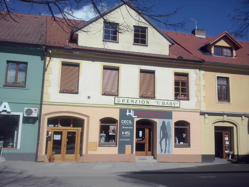 um edifício branco com um sinal em frente em Penzion U Báby em Třeboň