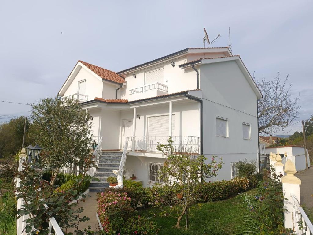 a white house with stairs and plants at Casa do Outeirinho in Campos