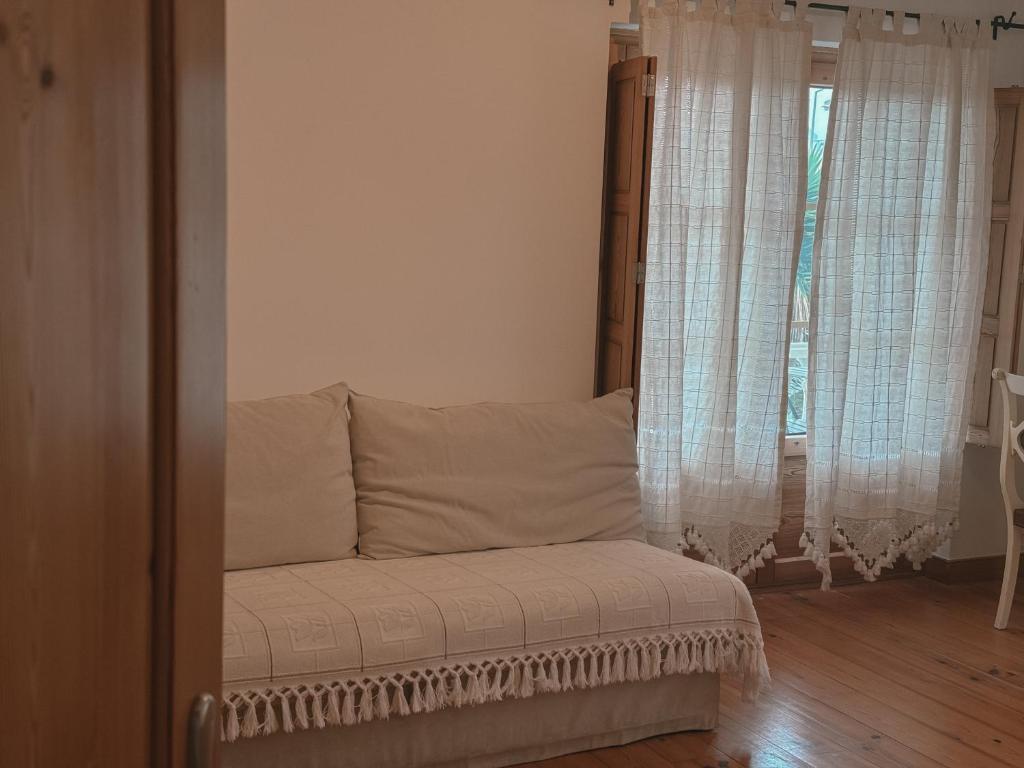 a couch in a room with a window at Quinta Amarela - B&B in Nazaré