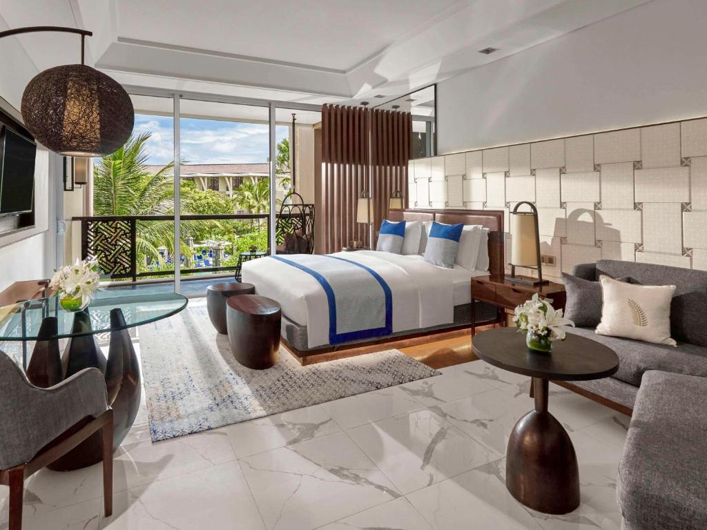 a bedroom with a bed and a living room at Sofitel Bali Nusa Dua Beach Resort in Nusa Dua