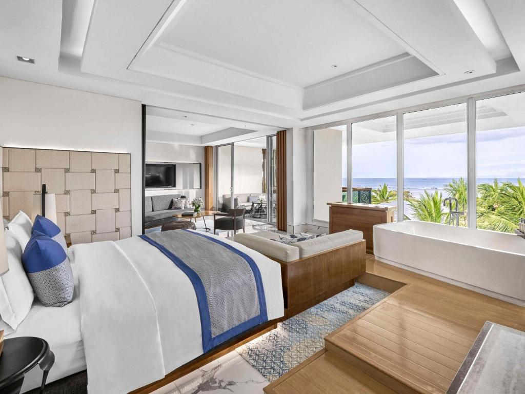 a bedroom with a king sized bed and a bath tub at Sofitel Bali Nusa Dua Beach Resort in Nusa Dua