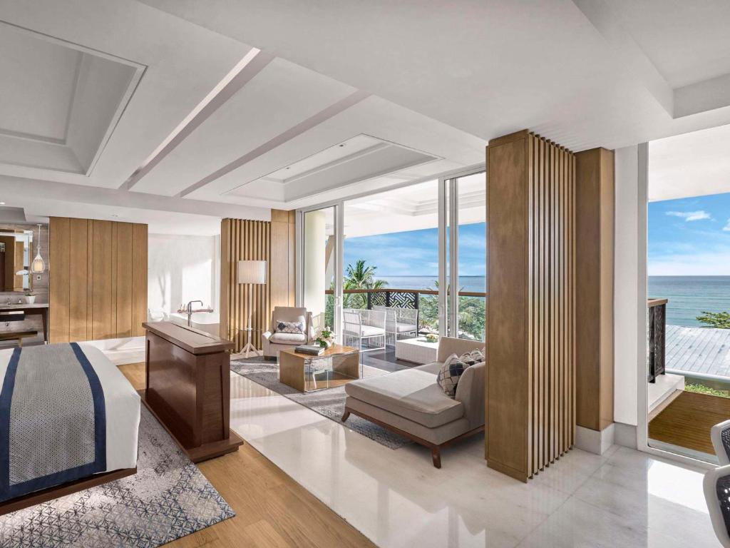 a bedroom with a bed and a living room with the ocean at Sofitel Bali Nusa Dua Beach Resort in Nusa Dua