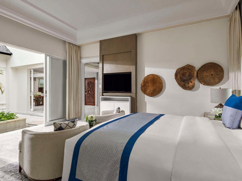 a bedroom with a large bed and a couch at Sofitel Bali Nusa Dua Beach Resort in Nusa Dua