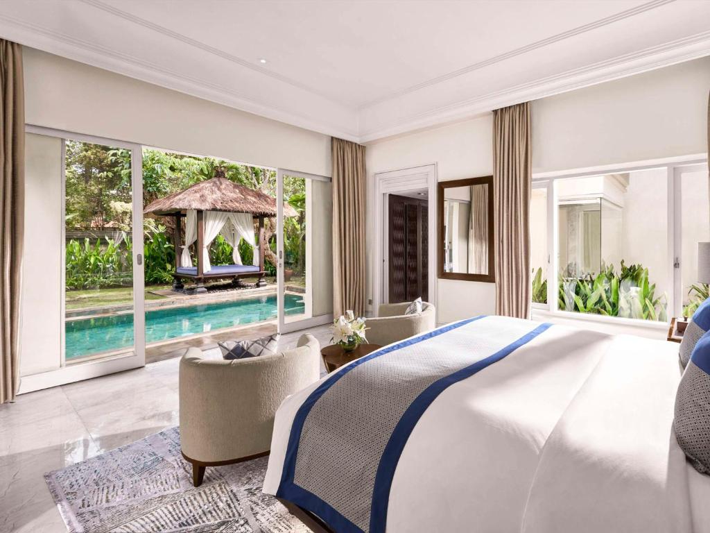 a bedroom with a large bed and a swimming pool at Sofitel Bali Nusa Dua Beach Resort in Nusa Dua