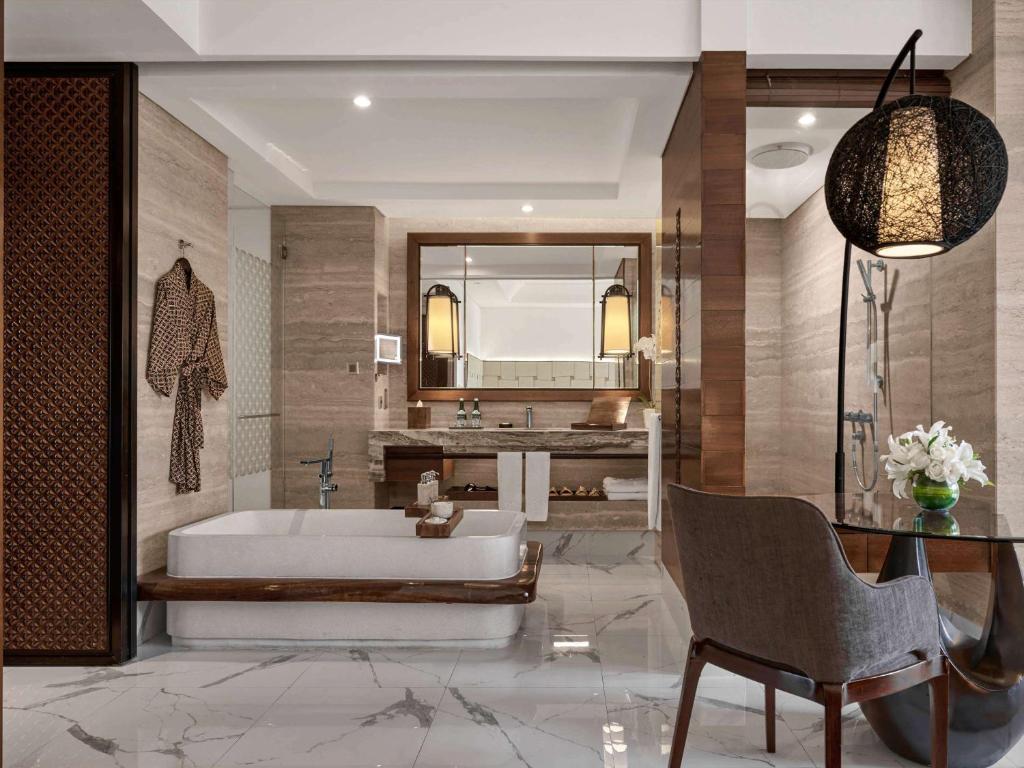 a bathroom with a tub and a large mirror at Sofitel Bali Nusa Dua Beach Resort in Nusa Dua