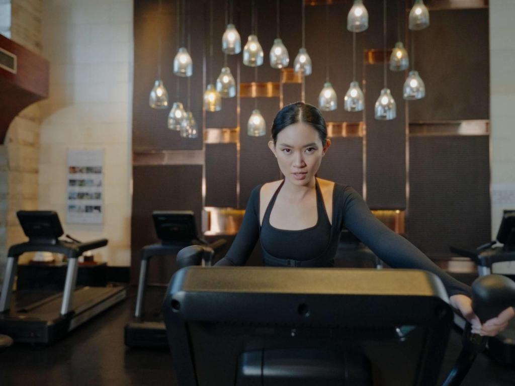 a woman sitting at a table in a gym at Sofitel Bali Nusa Dua Beach Resort in Nusa Dua