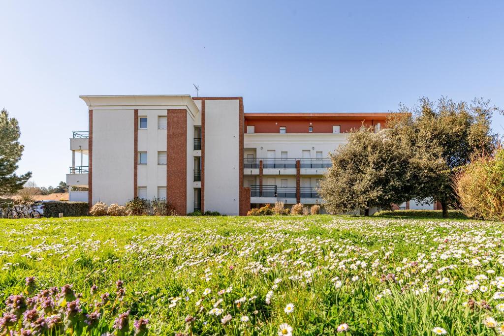 un immeuble de bureaux avec un champ de fleurs dans l'établissement 58 Plein Ouest, Plage Pied, à Pornic