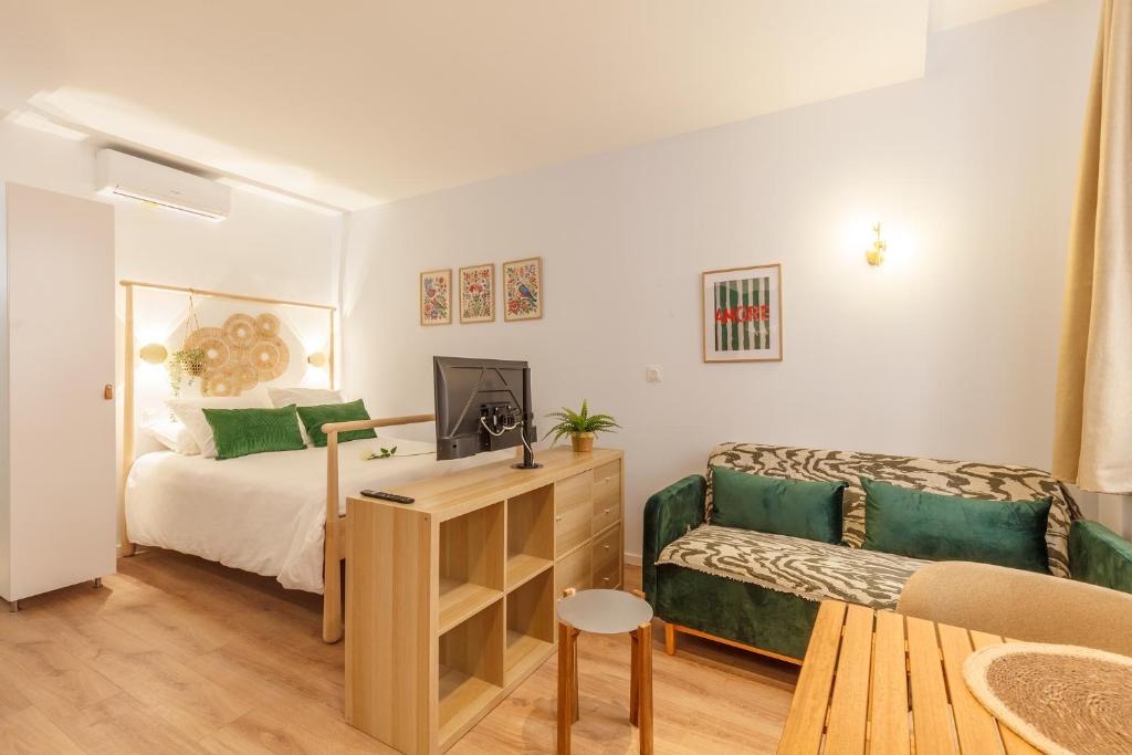 une petite chambre avec un lit et un canapé dans l'établissement Daumas 1 - Studio cosy & central, à Toulon