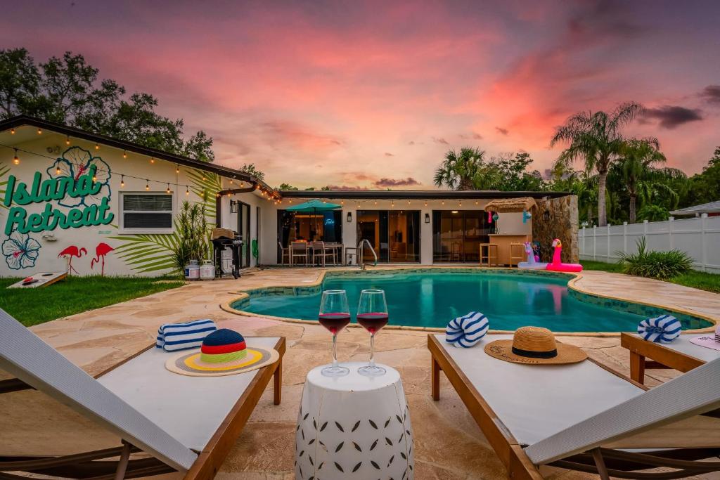 Casa con piscina y 2 mesas con copas de vino en Waterfront Oasis Htd Pool PuttPutt Bocce Ball, en Redington Shores