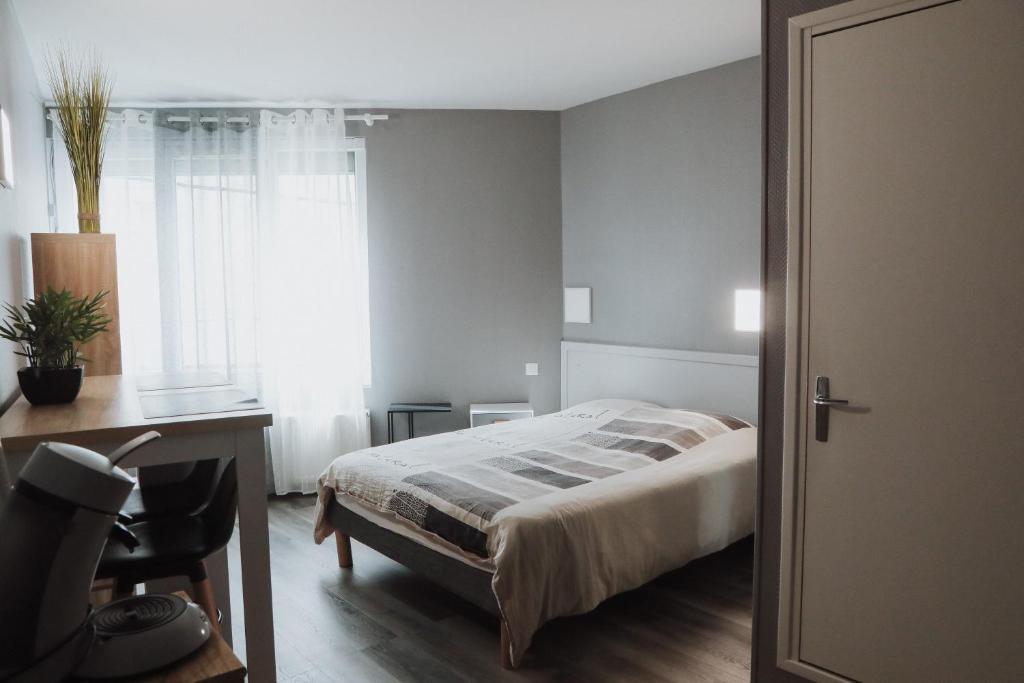 une chambre avec un lit, un bureau et une fenêtre dans l'établissement Appart hôtel Bourges, à Bourges