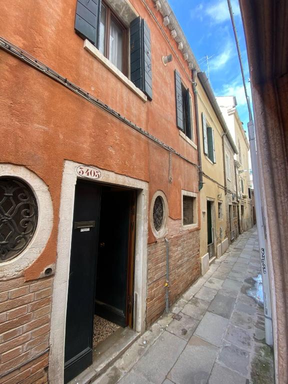 a brick building with a door open on a street at Domus Estia in Venice