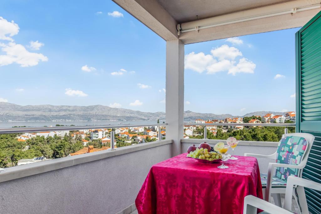 - une table sur un balcon avec vue sur la ville dans l'établissement Spacious & Charming Apartment 128 m2 with Sea View, à Supetar