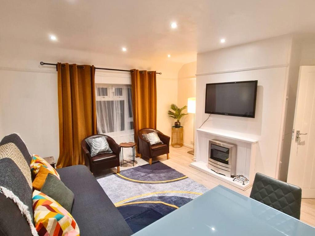 ein Wohnzimmer mit Sofa und Kamin in der Unterkunft Modern Penge East Apartment in Sydenham