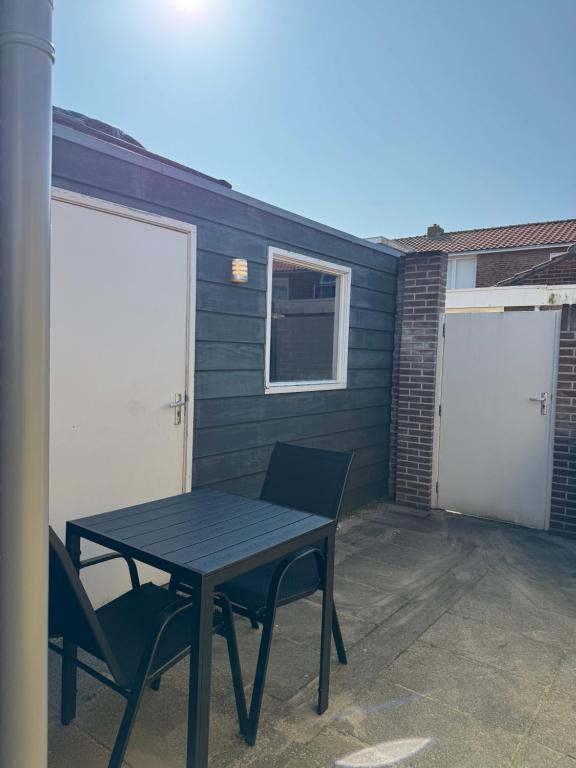 a table and chairs on a patio with two garage doors at Studio 41 Sunshine in Noordwijk aan Zee