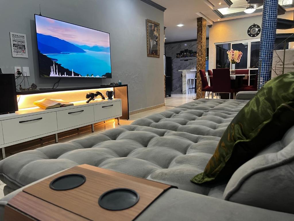 a living room with a large couch and a flat screen tv at CASA ALTO PADRÃO - CoP30 in Belém