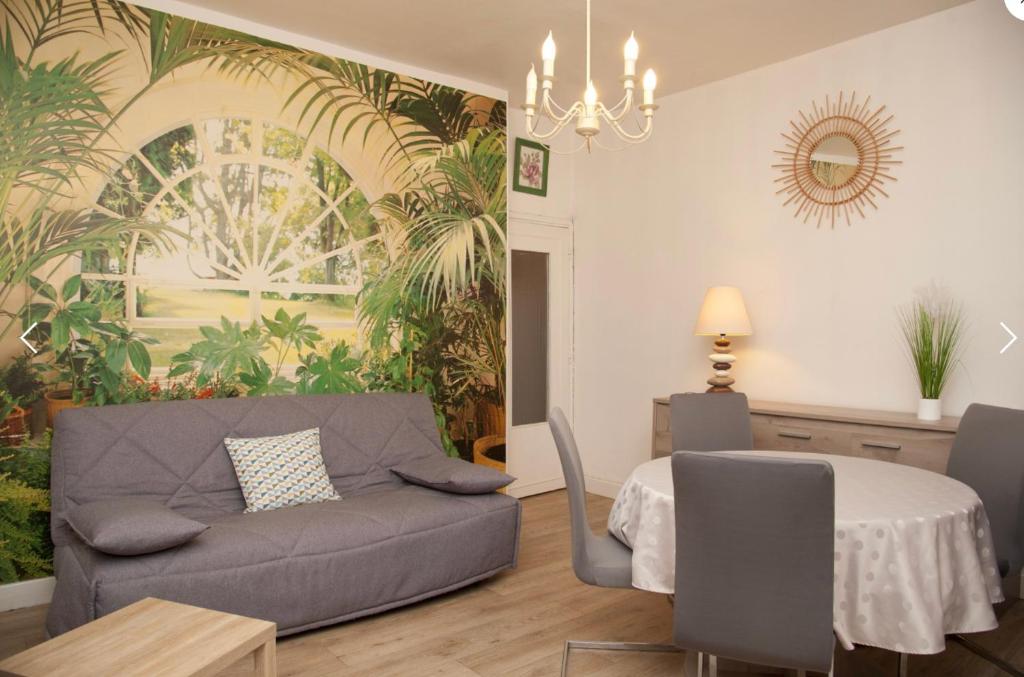 un salon avec un canapé et une table dans l'établissement Joli appartement avec vue, idéal pour votre cure, à Royat