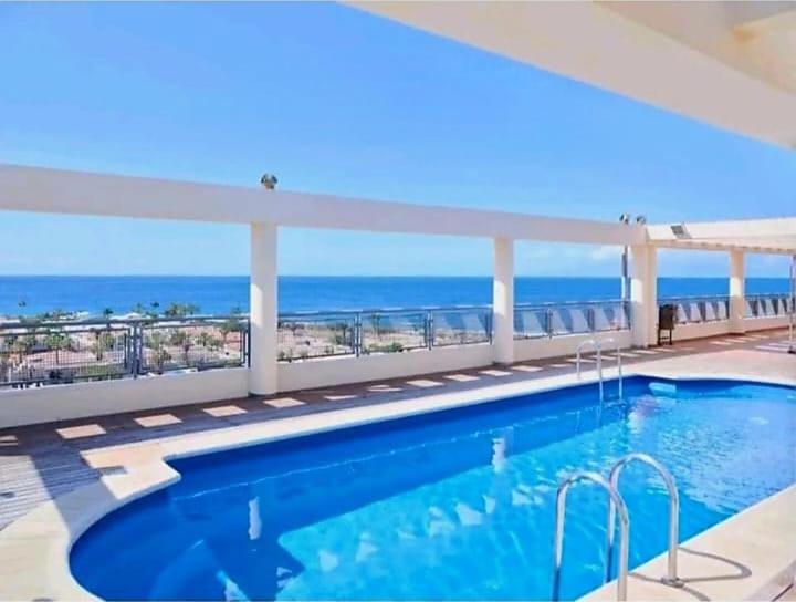 a swimming pool with a view of the ocean at Arenita 4G in Palm-Mar