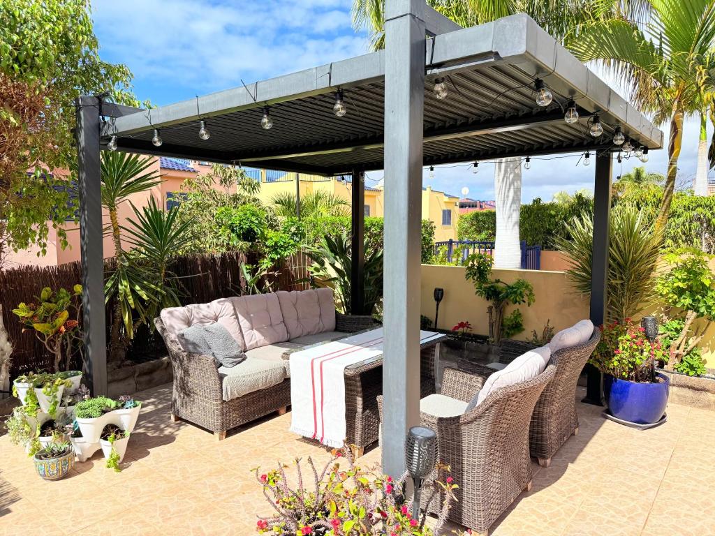une pergola sur une terrasse avec un canapé et une table dans l'établissement Cozy Corner Close to Beach, Golf and Shopping, à San Bartolomé