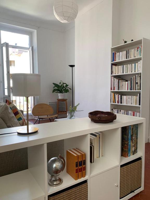 un salon avec une grande étagère blanche et des livres dans l'établissement Appartement Atelier mistral, à Marseille