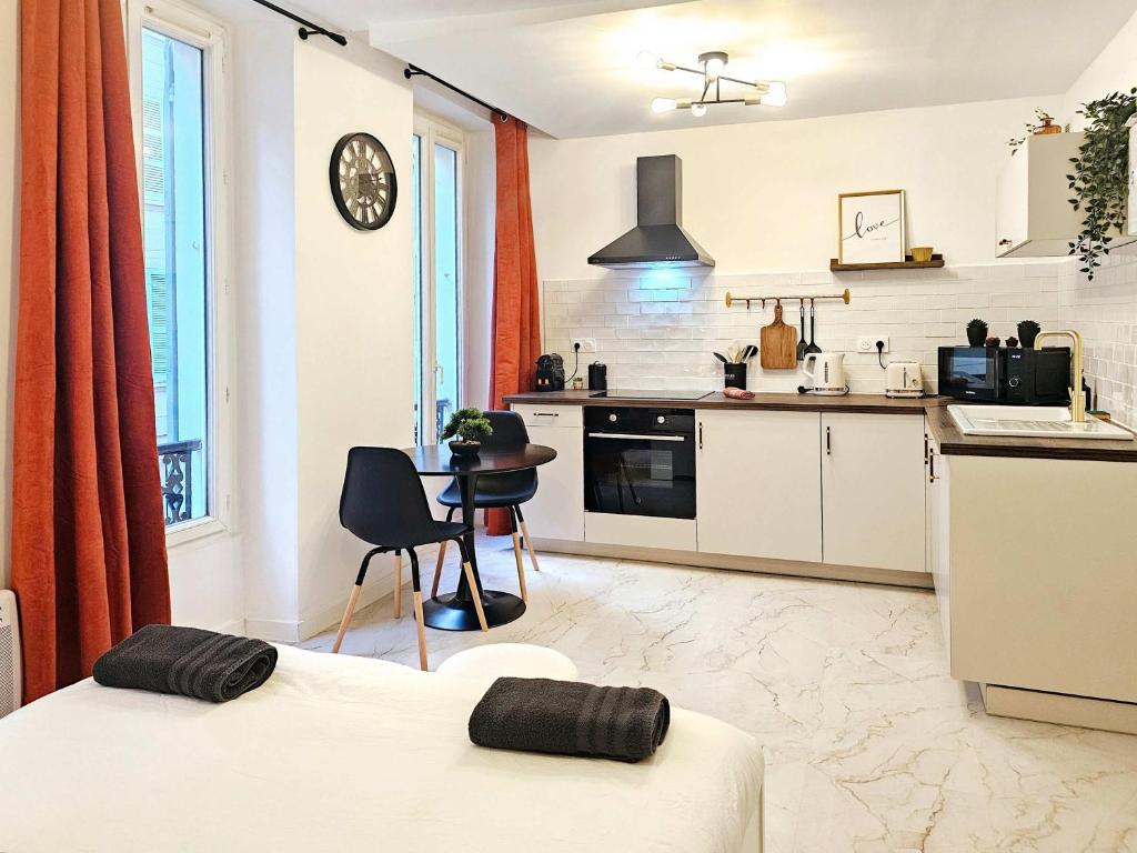 une cuisine avec des armoires blanches et une table et des chaises dans l'établissement Niala Studio in city center of Marseille at Vieux-Port and Opera, à Marseille